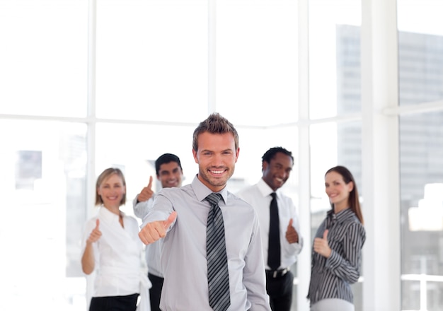 Self-assured business manager standing at the camera with his team 