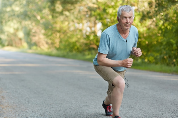 Self assured senior sportsman ready to start jogging marathon