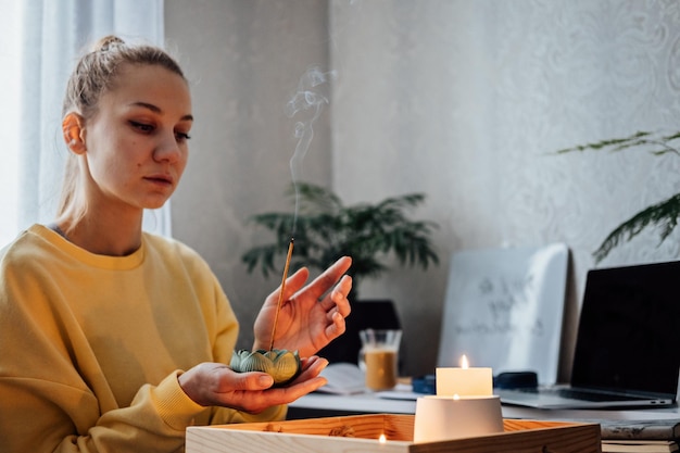 Self care mental health Young woman sitting near table with lights candles Aroma Sticks enjoy meditation at home No stress healthy habit mindfulness lifestyle anxiety relief concept
