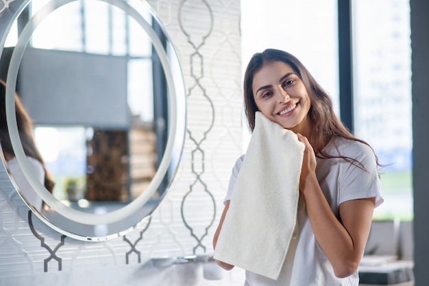 Self-care. A woman drying her skin with a towel after spa procedures