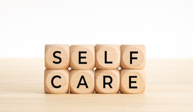 Self care word on wooden blocks on wood table.