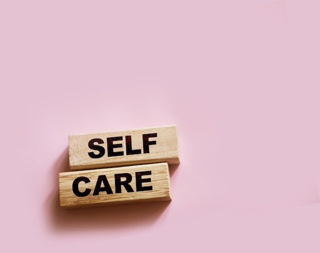 Self care words on wooden blocks self treatment concept pink background