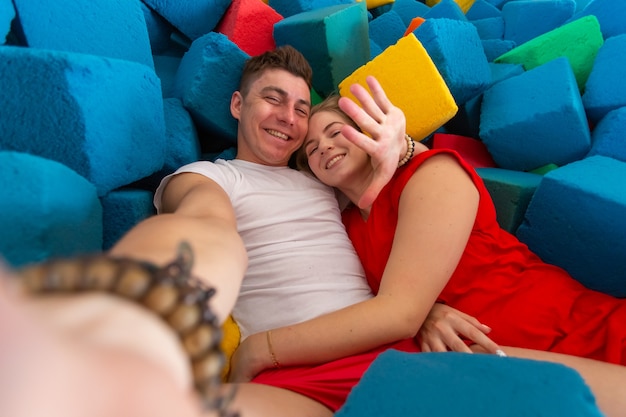 Self portrait of funny comic couple shooting selfie on trampoline.