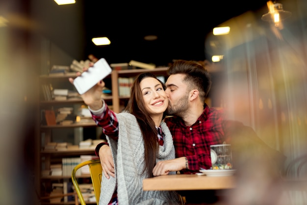 Self portrait making at restaurant couple enjoying together. Photo mobile posing for social networks.