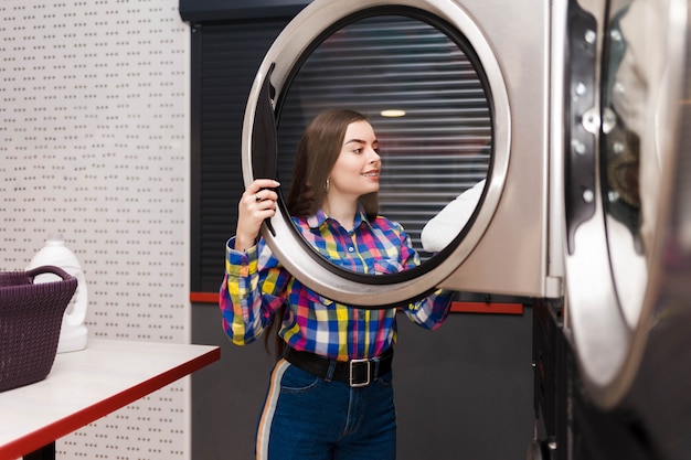 self serviece laundrette client takes things out of the dryer