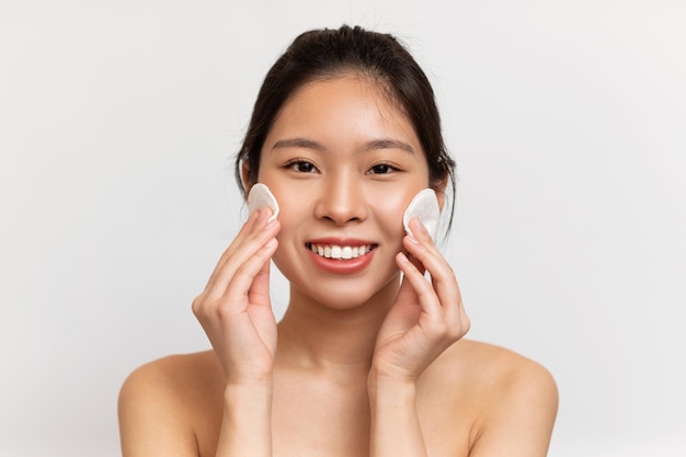 Selfcare concept young asian lady with beautiful skin cleansing face with cotton pads making daily