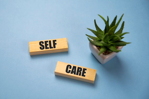 Selfcare word on lightbox on blue background flat lay. Take care of yourself.