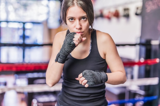 Selfdefense MMA and Kickboxing ring Sportswoman with determination and confident working out and exercise punching with cardio boxing