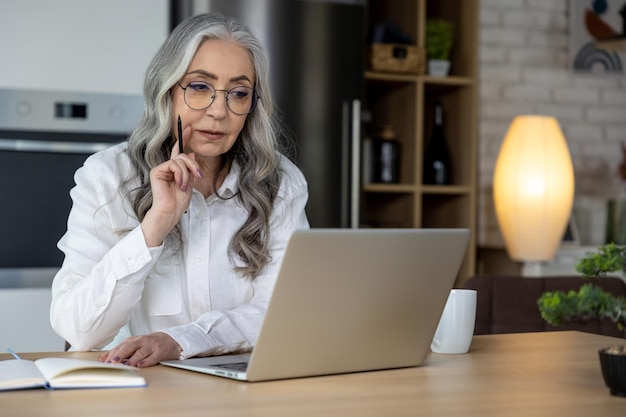 Selfemployed Elegant goodlooking senior woman working on laptop