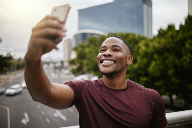 Photo selfie black man and in city with smile on vacation and cheerful for break casual and relax african american male guy and smartphone for social media connection and in town for chill or weekend