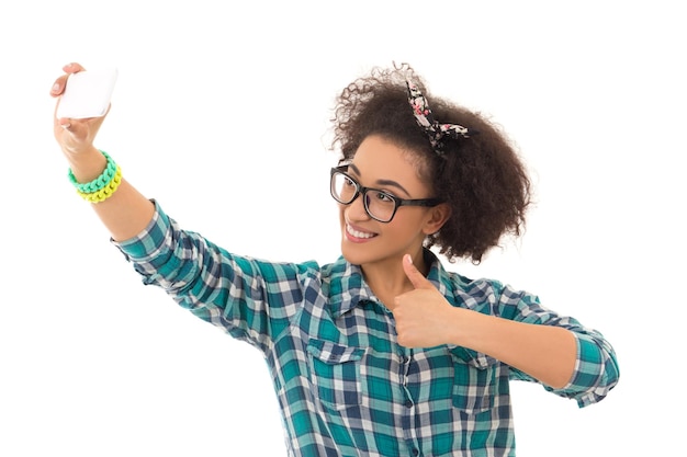 Foto concetto di selfie bella ragazza adolescente afroamericana che scatta una foto di se stessa con il telefono con fotocamera isolato su sfondo bianco