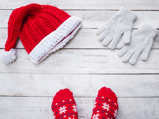 Photo selfie feet wearing red sock and handicraft santa claus hat on vintage wood