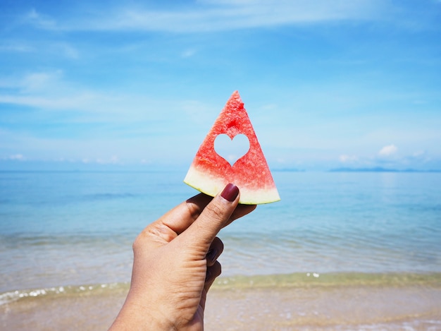 Selfie hand holding watermelon over summer beach 