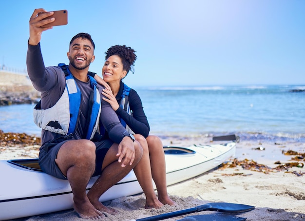 Selfie-kajak en een stel op het strand in de zomer samen voor vrijheidsvakantie of vakantiereizen Ontspan liefde of glimlach met een sportieve man en vrouw op een boot aan de oceaan of zee voor avontuur