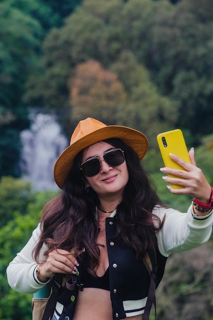 Photo selfie in nature woman enjoying a waterfalltravel concept exploration vblog influencer social media