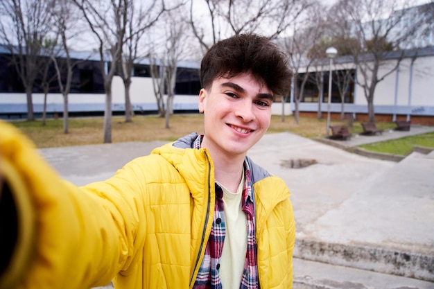 Selfie ritratto di un ragazzo studente guardando la telecamera all'aperto campus universitari stile di vita giovane p