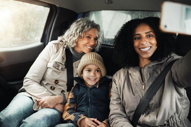 充実した時間と休暇を一緒に過ごすための、車でのロードトリップ中の自撮り笑顔と家族 幸せな旅行と、ソーシャルメディア用に休暇中に写真を撮る母親と祖母と子供