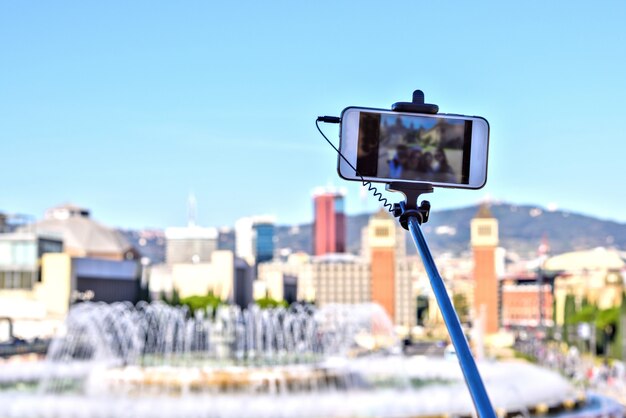 Bastone di selfie sulla priorità bassa del cielo blu. smart phone, barcellona, ​​spagna