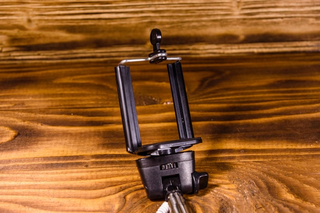 Bastone per selfie con morsetto regolabile su tavolo in legno rustico