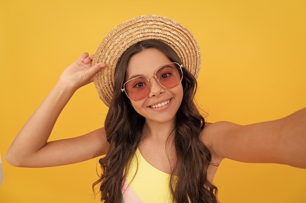 Selfie time child wear straw hat and glasses cheerful teen girl with curly hair