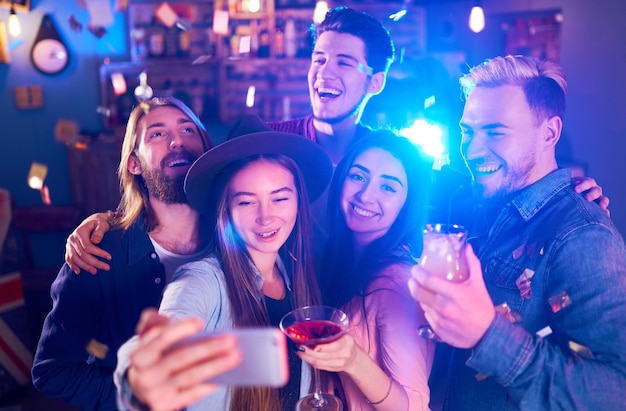 Selfie 시간 젊은 그룹의 친구는 나이트 클럽에서 파티를 하고 음료를 건배합니다.