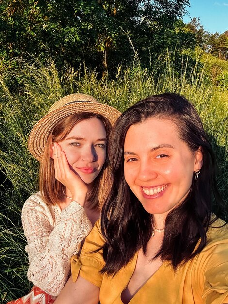 A selfie of two friends in the yard in the summer