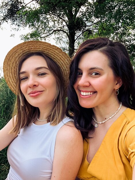 Selfie of two smiling young women outdoors in summer