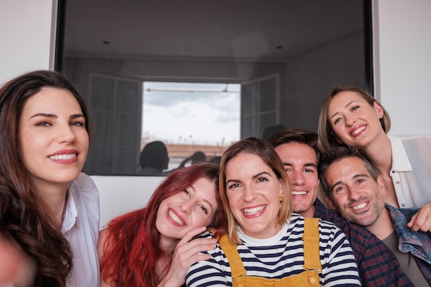 Selfie van een groep vrienden verzameld op de bank thuis glimlachend Concept vriendschap leuke binding