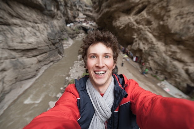 Selfie van opgewonden gekrulde jonge hipster man