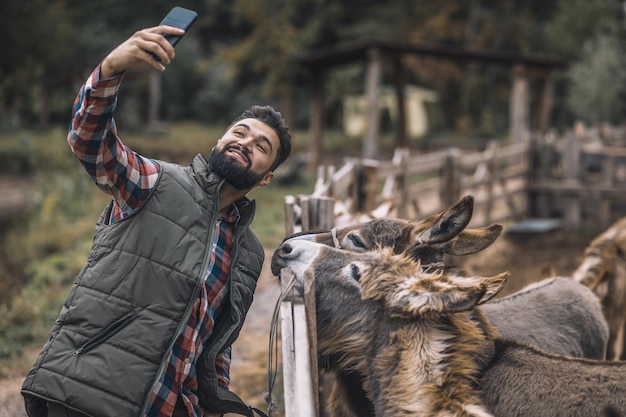 selfie. Vrolijke boer die selfie maakt met ezels