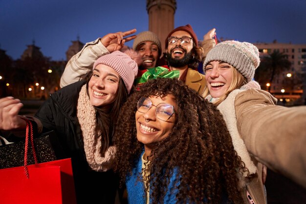 Selfie vrolijke jonge multi-etnische groep met boodschappenzakken kerstcadeaus gelukkige vrienden winter