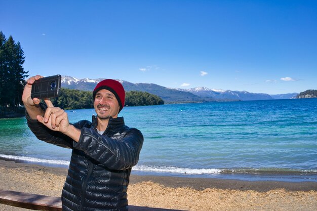 Selfie with your cell phone from your vacation in front of a lake in Patagonia