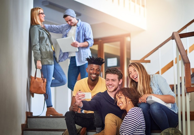 Selfies met de campuscrew Shot van een groep universiteitsstudenten die een selfie maken op de trap op de campus