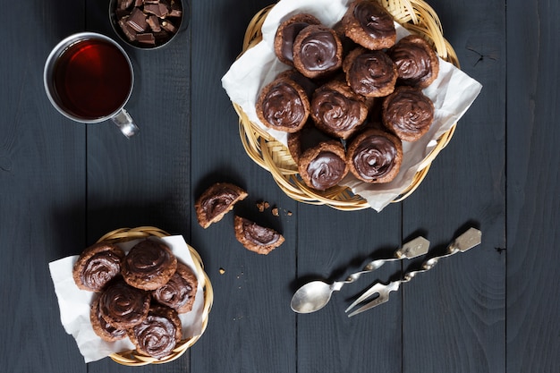 Selfmade chocolate cookies with tea on a dark table