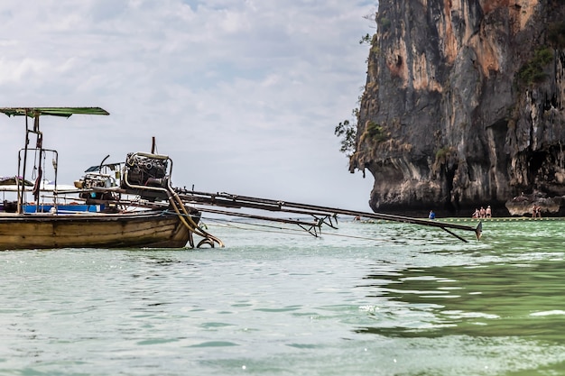 selfmade engine from pickup truck is mounted on longtailed motor boat sandy beach with tourists