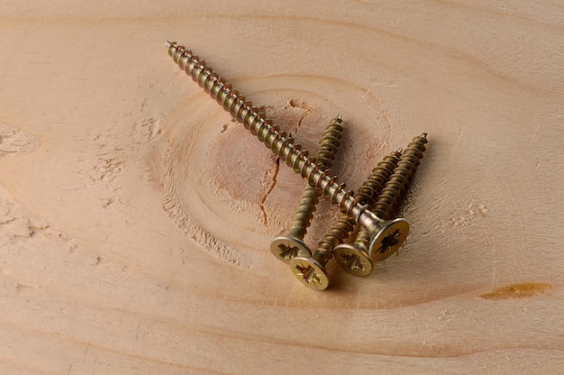 Selftapping screws on the background of a wooden board Closeup
