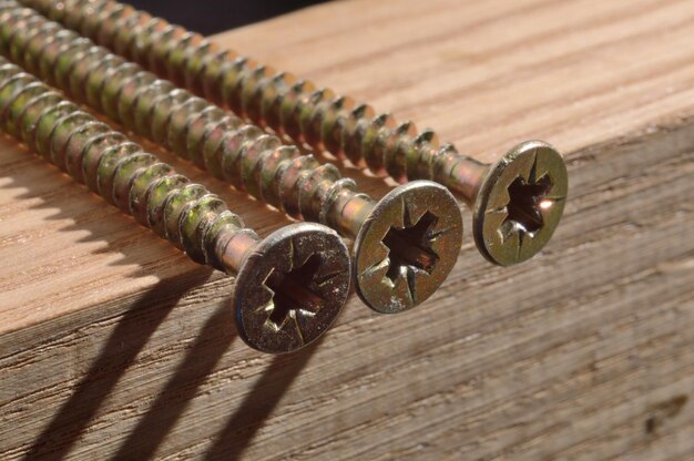 Selftapping screws on the background of a wooden board Closeup