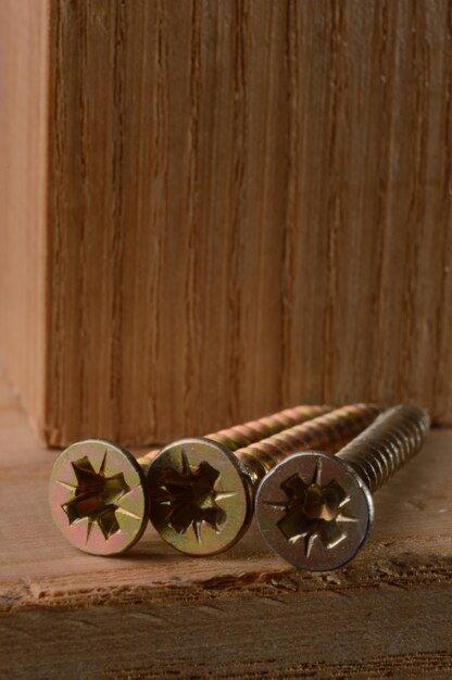 Selftapping screws on the background of a wooden board Closeup