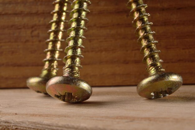 Selftapping screws on the background of a wooden board Closeup