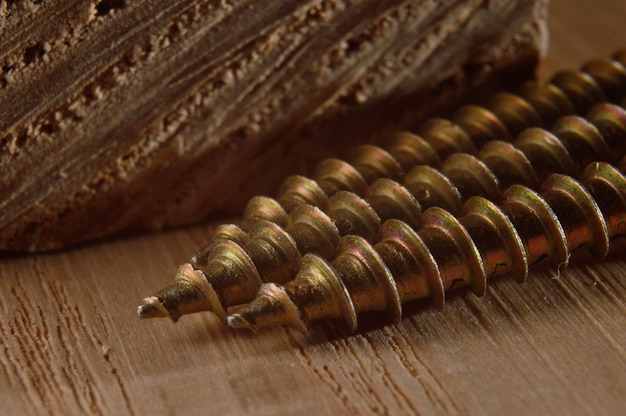 Selftapping screws on the background of a wooden board Closeup