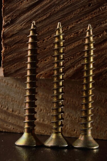 Selftapping screws on the background of a wooden board Closeup