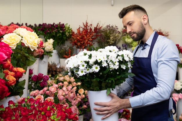 Seller in a flower center surrounded by a large number of fresh bouquets and flowers