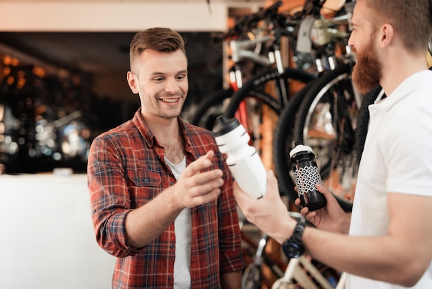 Seller Helps Guy Choose Water Bottle for Bicycle.