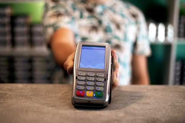 A seller holding and giving the payment terminal