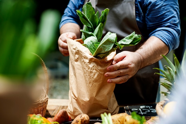 A seller putting vegetable in a bag