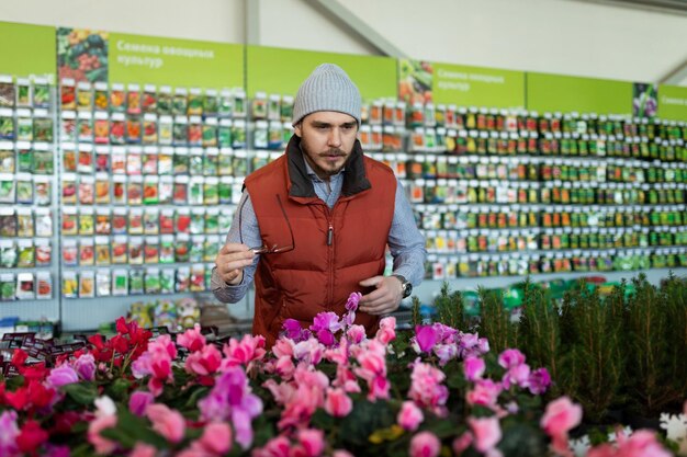 Seller of a store of live plants and seeds looks at the camera with a smile