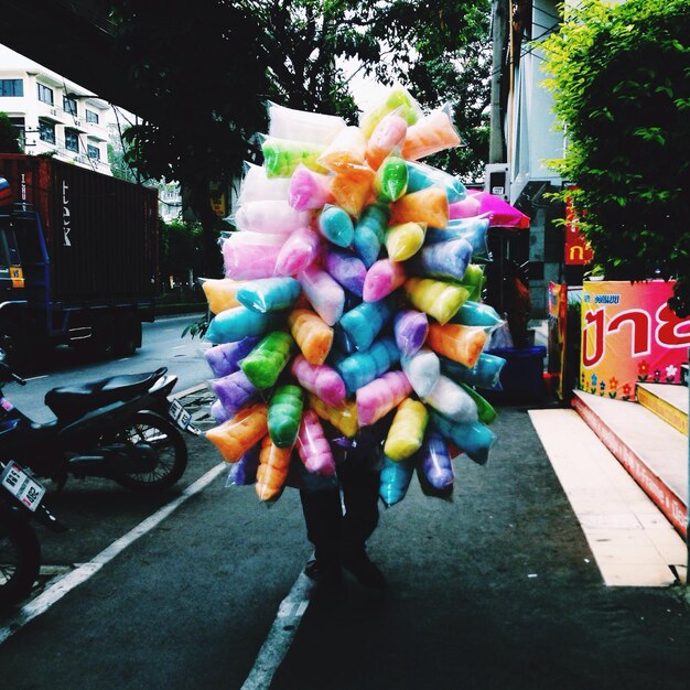 Photo seller with multi colored candy floss on sidewalk