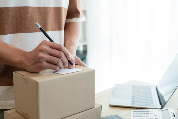 the seller writing his customer's address on the parcel and being ready for sending it