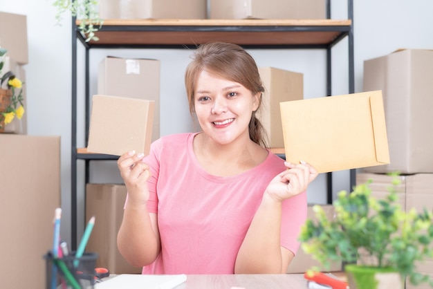 집에서 온라인 작업 판매 포장 상자를 들고 집에서 일하는 여성 사업주