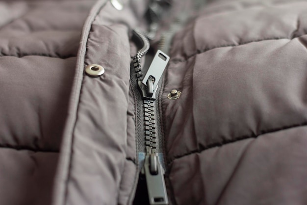 Semi-buttoned plastic tractor lock on a black down jacket.